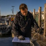 Salon nautique cap d agde 2025 : homme examine fiche technique au port